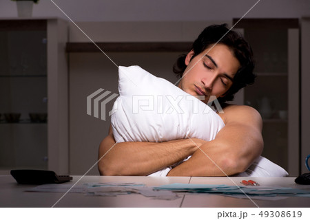 Young man calculating expences night at home  49308619