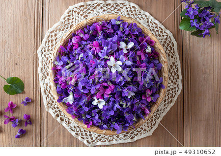 Wood violet flowers in a wicker basket, top view 49310652