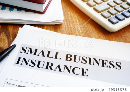 Small business insurance policy on a wooden desk. 49313378