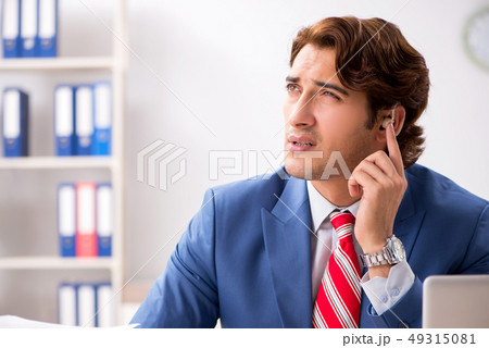 Deaf employee using hearing aid in office 49315081