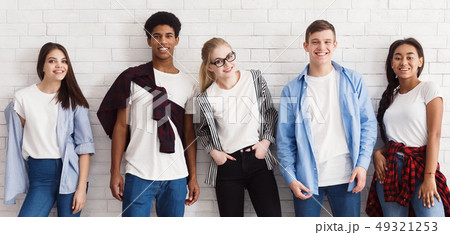 Stylish students posing over white wall, crop 49321253