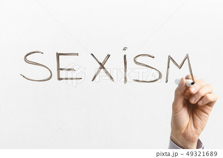 Man writing word SEXISM on glass board Man writing word SEXISM on glass board 49321689