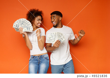 Cheerful african-american man and woman enjoying lots of money 49321836