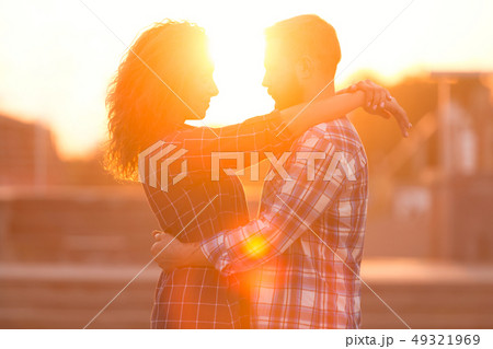Couple cuddling, enjoying beautiful sunset, in the city Couple cuddling, enjoying beautiful sunset, in the city 49321969