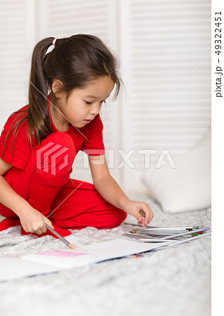 little child girl draws with pencils at home little child girl draws with pencils at home 49322451