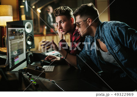 Sound engineer working in a music studio 49322969