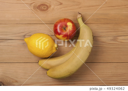 Lemon apple and bananas on a wooden background. Lemon apple and bananas on a wooden background. 49324062