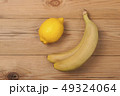 Lemon and bananas on a wooden background. 49324064
