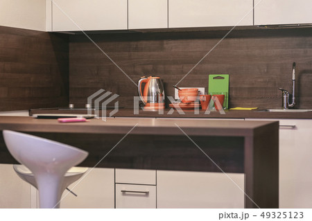 Modern kitchen with countertops, table and bar stool, dishes, kitchen loft style Modern kitchen with countertops, table and bar stool, dishes, kitchen loft style 49325123