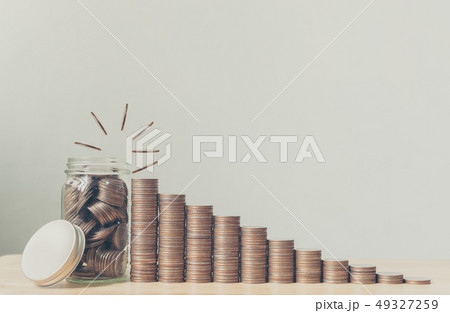 Coin in glass bottle with money stack step up 49327259