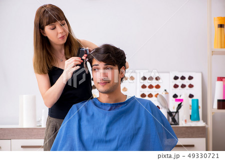 Young attracrive man visiting female barber  49330721