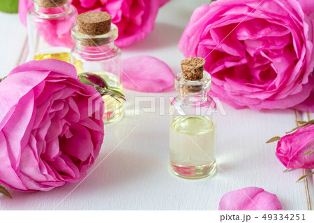A bottle of essential oil with fresh roses 49334251