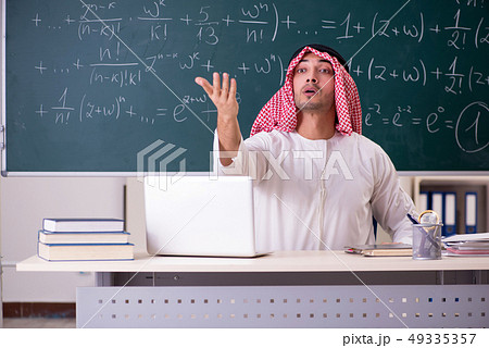 Arab teacher in front of chalkboard Arab teacher in front of chalkboard 49335357