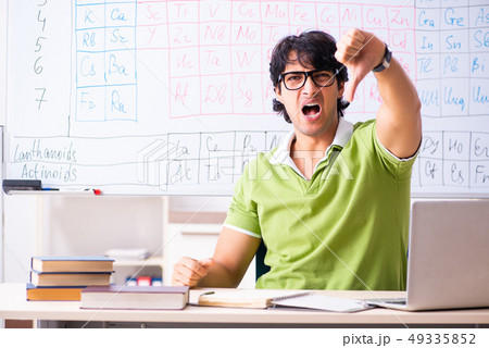 Young male student chemist in front of periodic table Young male student chemist in front of periodic table 49335852