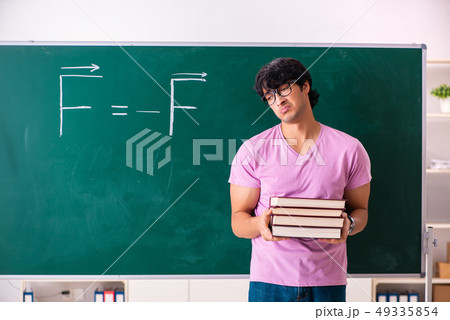 Young male physic standing in front of the green board 49335854