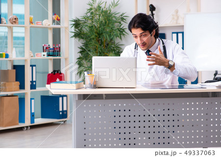 Young handsome doctor in telemedicine concept  49337063