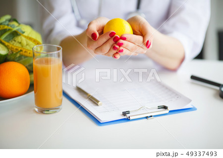 Conceptual Photo Of A Female Nutritionist With Fruits On The Desk Conceptual Photo Of A Female Nutritionist With Fruits On The Desk 49337493