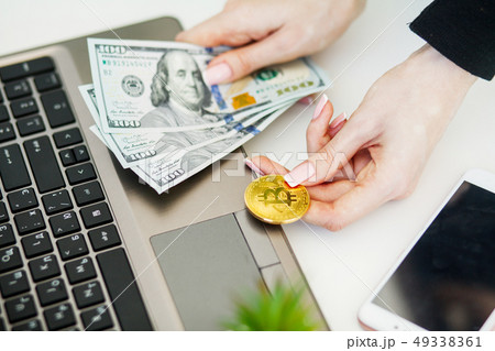Close-up woman buying online with cryptocurrency concept, woman holding golden crypto coin Close-up woman buying online with cryptocurrency concept, woman holding golden crypto coin 49338361
