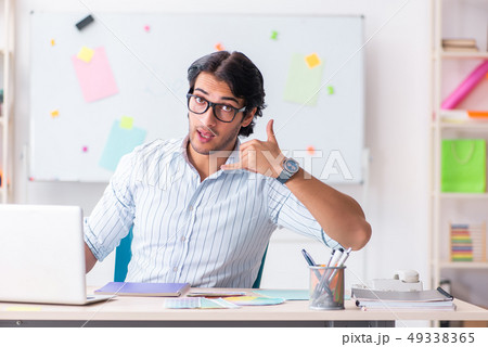 Young handsome male designer working in the office Young handsome male designer working in the office 49338365