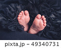 Soft newborn baby feet against a black blanket 49340731