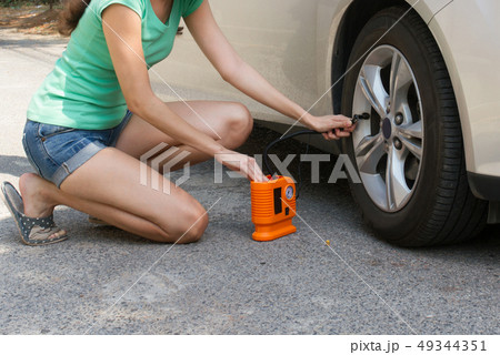 woman checking air tyre pressure with air pressure 49344351