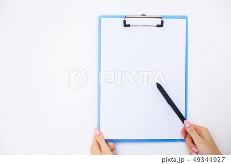 Office Hand Holding a Folder with a White Color Paper on the Background of the White Table Office Hand Holding a Folder with a White Color Paper on the Background of the White Table 49344927