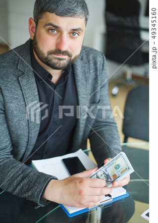 Business Man Sitting at the Desk and Signing Contract. Man takes Bribe for Signing the Contract Business Man Sitting at the Desk and Signing Contract. Man takes Bribe for Signing the Contract 49345160