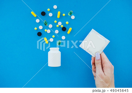 Pills or Condom. Antibiotics from venereal diseases. Concept of safe sex. Pills and condom lie on a 49345645