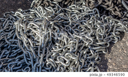 galvanized chain lies on the road under the rays of the Sun galvanized chain lies on the road under the rays of the Sun 49346590