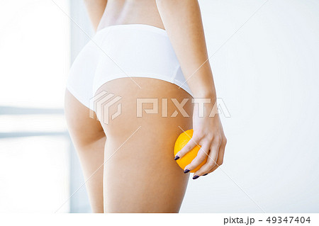 Diet and skin care. Beautiful Slim Woman Figure With an Orange Near Her Ass Diet and skin care. Beautiful Slim Woman Figure With an Orange Near Her Ass 49347404