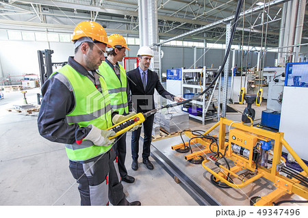 Workers with metal sheet lifting device 49347496