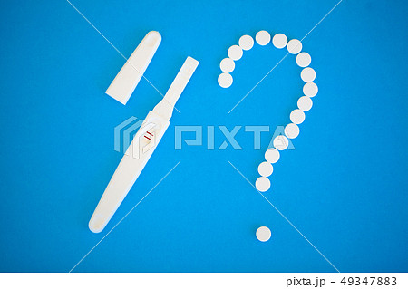 Pregnancy planning concep. Pregnancy test positive with two stripes and contraceptive pill on blue 49347883