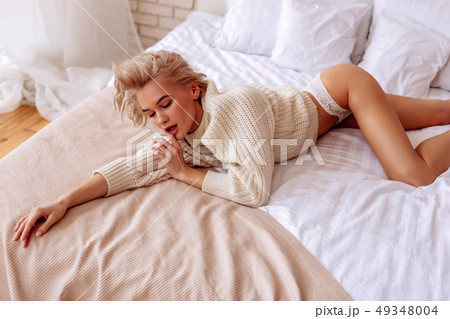 Professional photo model posing in bed for magazine cover 49348004