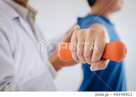 Doctor physiotherapist assisting a male patient 49348922