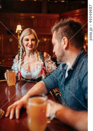 Drunk man with beer mug and waitress at counter 49349687