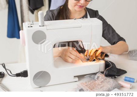 People, tailor and fashion concept - close up of fashion designer in glasses sitting at a table People, tailor and fashion concept - close up of fashion designer in glasses sitting at a table 49351772
