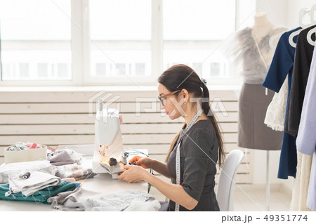 people, dressmaker, tailor and fashion concept - young fashion designer in her showroom people, dressmaker, tailor and fashion concept - young fashion designer in her showroom 49351774