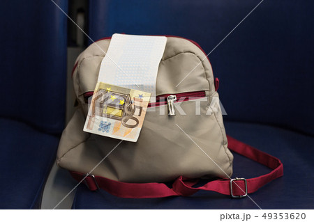 backpack with ticket, money 50 euros in pocket on blue chair in train backpack with ticket, money 50 euros in pocket on blue chair in train 49353620
