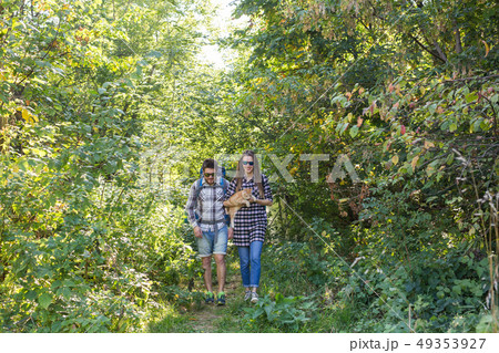 Travel, adventures, hike, tourism and nature concept - Tourist couple with cat walking in the woods 49353927