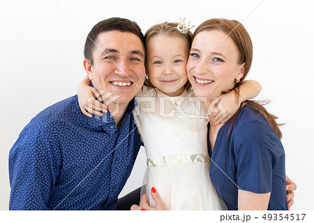people, family and happiness concept - Mother and father with little daughter over white background 49354517
