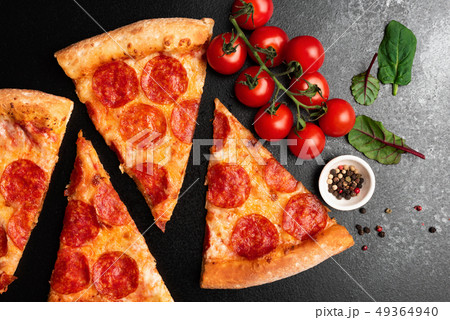 Pepperoni pizza slices on black background top view Pepperoni pizza slices on black background top view 49364940