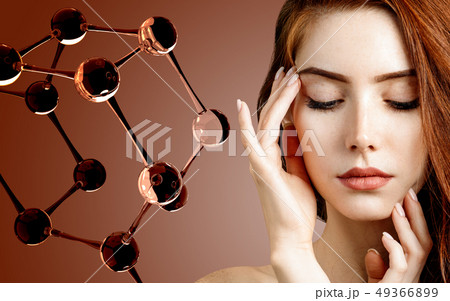 Beautiful redehead woman near big white molecule structure. 49366899