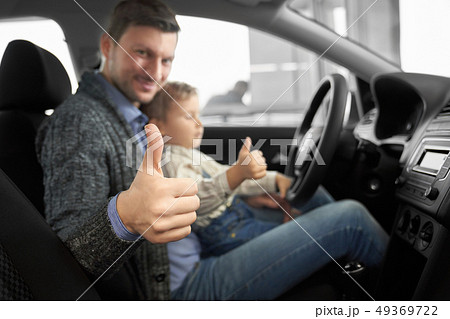 Caring father sitting with son in new comfortable auto Caring father sitting with son in new comfortable auto 49369722