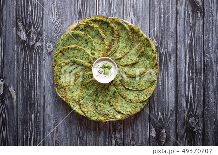 Spinach pancakes on a gray wooden table.  49370707