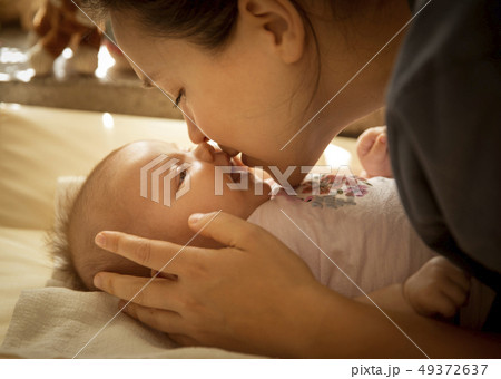 Mother kissing her little baby girl Mother kissing her little baby girl 49372637