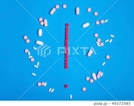 Exclamation mark from red medicine pills on blue 49372985