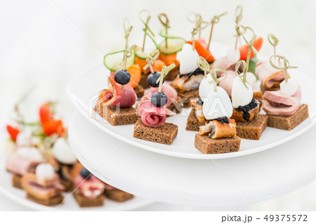 Buffet table. Assortment of canapes. Banquet service in restaurant. Catering food, snacks on white Buffet table. Assortment of canapes. Banquet service in restaurant. Catering food, snacks on white 49375572