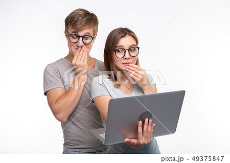 Nerds, study, people concept - a couple of people look at the laptop and look like surprised Nerds, study, people concept - a couple of people look at the laptop and look like surprised 49375847