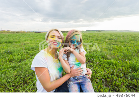 Happiness, Holi festival and holidays concept - two young women and girl having fun on holi festival Happiness, Holi festival and holidays concept - two young women and girl having fun on holi festival 49376044