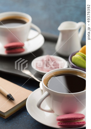 Two cups of coffee and sweets on table Two cups of coffee and sweets on table 49376392